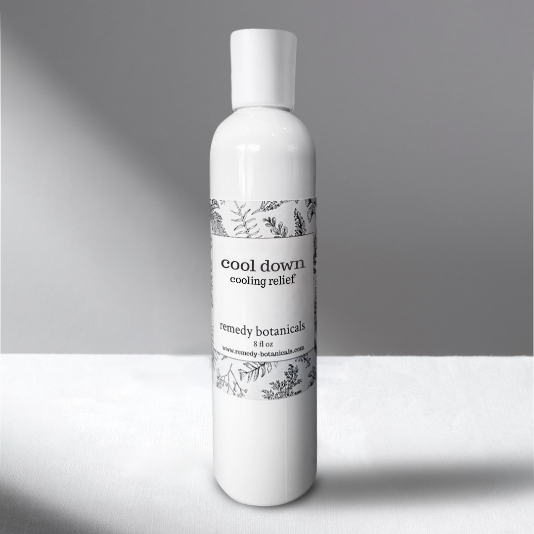 A 8oz white bottle of Cool Down Cooling Relief stands against a softly lit gray background, exuding a clean and calming appearance.